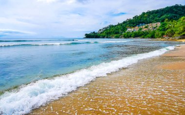 Kalim Plajı tropikal manzara manzarası mavi gökyüzü turkuvaz su dalgaları ve kayalarla Patong Sahili Kathu Bölgesi Phuket Adası Güney Tayland Güney Asya Bölgesi.