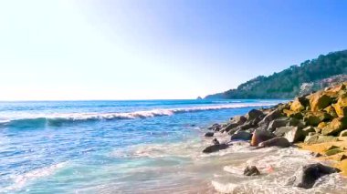 Kalim Sahili tropikal kayalık manzara manzarası turkuaz mavisi berrak su dalgaları ile Patong Sahili Kathu Bölgesi Phuket Adası Güney Tayland 'da kum ve kayalar.