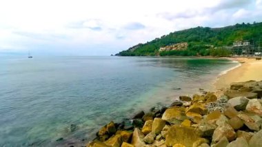 Kalim Sahili tropikal kayalık manzara manzarası turkuaz mavisi berrak su dalgaları ile Patong Sahili Kathu Bölgesi Phuket Adası Güney Tayland 'da kum ve kayalar.