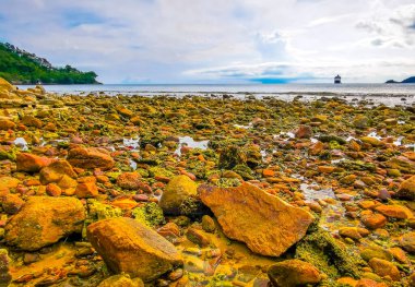 Kalim Sahili tropikal kayalık manzara manzarası turkuaz mavisi berrak su dalgaları ile Patong Sahili Kathu Bölgesi Phuket Adası Güney Tayland 'da kum ve kayalar.