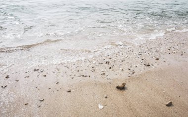 Plaj kumları ve çakıl taşları kayalar rengarenk midyeler mercanlar ve turkuaz mavisi berrak su dokusu Patong Kalim Plajı Kathu Bölgesi Phuket Adası Güney Tayland Bölgesi.