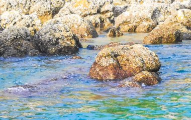 Rocky Kalim Sahili tropikal sahil kıyısı turkuvaz mavisi berrak su dalgaları kum kayaları ve kayalar Patong Sahili Kathu Bölgesi Phuket Adası Güney Tayland Bölgesi.
