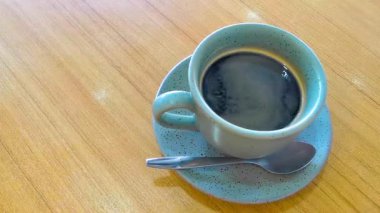 Güneydoğu Asya 'da Patong Plajı' ndaki Kathu Bölgesi Phuket Adası Bölgesi Tayland Eyaleti 'nde bir kafeteryada kaşık ve tabakla birlikte bir bardak americano kahvesi..