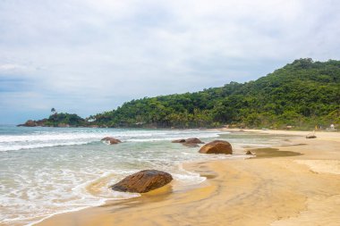 Aventureiro Sahili tropikal manzara manzarası turkuaz su dalgaları palmiye ağaçları ve kayalar Ilha Grande Büyük Adası Angra dos Reis Rio de Janeiro Brezilya.
