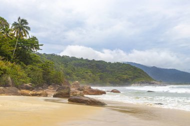 Aventureiro Sahili tropikal manzara manzarası turkuaz su dalgaları palmiye ağaçları ve kayalar Ilha Grande Büyük Adası Angra dos Reis Rio de Janeiro Brezilya.