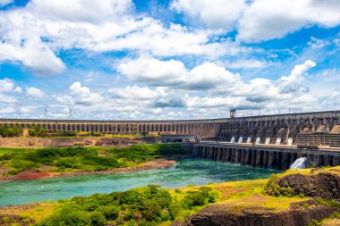 Brezilya 'nın en büyük barajı. Paraguay sınırındaki enerji üretimi için Itaipu. Elektrik direkleriyle elektrik direkleri. Foz do Iguacu State of Parana Brazil' de su nehri ve mavi gökyüzü inşa ediliyor..
