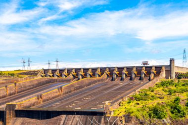 Brezilya 'nın en büyük barajı. Paraguay sınırındaki enerji üretimi için Itaipu. Elektrik direkleriyle elektrik direkleri. Foz do Iguacu State of Parana Brazil' de su nehri ve mavi gökyüzü inşa ediliyor..