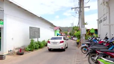 Thalang Bölgesi Phuket Eyaleti Tayland 11. Güney Tayland 'daki Phuket Adası' ndaki Mai Khao 'da trafik evleri ve binalarla tropikal doğada Şubat 2020 Renkli yol caddesi.