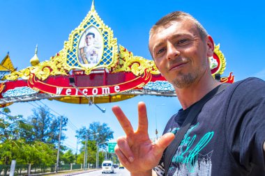 Yakışıklı erkek turist rengarenk kraliyet kralı hoş geldin kapısı girişi Phuket Uluslararası Havalimanı Mai Khao Thalang Bölgesi Phuket Adası Tayland.