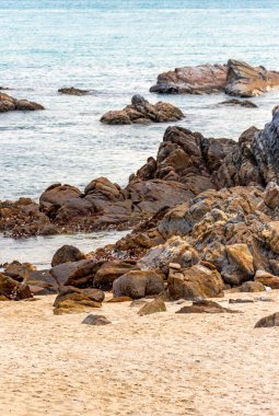 Rocky Kalim Sahili tropikal sahil kıyısı turkuvaz mavisi berrak su dalgaları kum kayaları ve kayalar Patong Sahili Kathu Bölgesi Phuket Adası Güney Tayland Bölgesi.