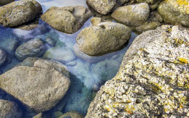 Rocky Kalim Sahili tropikal sahil kıyısı turkuvaz mavisi berrak su dalgaları kum kayaları kaya ve midye kabuklu kayalar Patong Sahili Kathu Phuket Adası Güney Tayland.