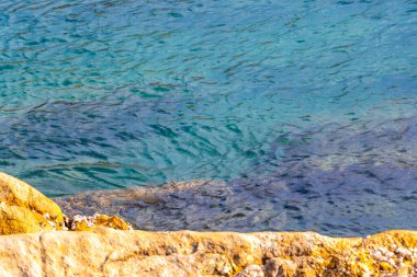 Rocky Kalim Sahili tropikal sahil kıyısı turkuvaz mavisi berrak su dalgaları kum kayaları kaya ve midye kabuklu kayalar Patong Sahili Kathu Phuket Adası Güney Tayland.