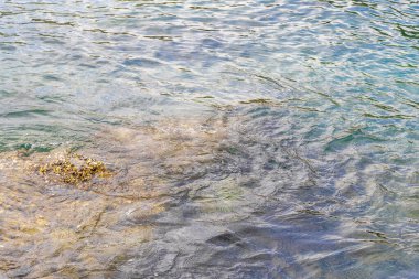 Rocky Kalim Sahili tropikal sahil kıyısı turkuvaz mavisi berrak su dalgaları kum kayaları kaya ve midye kabuklu kayalar Patong Sahili Kathu Phuket Adası Güney Tayland.