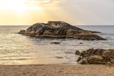 Rocky Kalim Sahili tropikal sahil kıyısı turkuvaz mavisi berrak su dalgaları kum kayaları kaya ve midye kabuklu kayalar Patong Sahili Kathu Phuket Adası Güney Tayland.