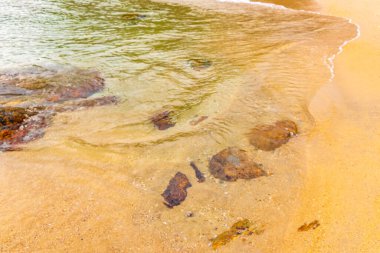 Rocky Kalim Sahili tropikal sahil kıyısı turkuvaz mavisi berrak su dalgaları kum kayaları ve kayalar Patong Sahili Kathu Bölgesi Phuket Adası Güney Tayland Bölgesi.