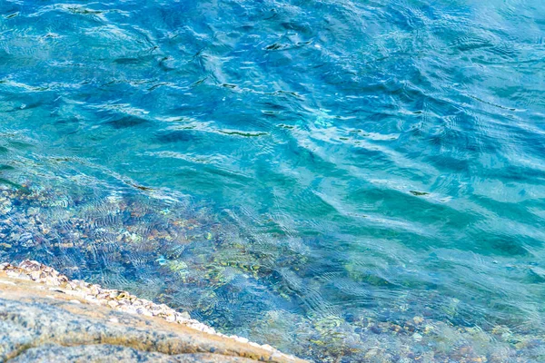 Rocky Kalim Sahili tropikal sahil kıyısı turkuvaz mavisi berrak su dalgaları kum kayaları kaya ve midye kabuklu kayalar Patong Sahili Kathu Phuket Adası Güney Tayland.