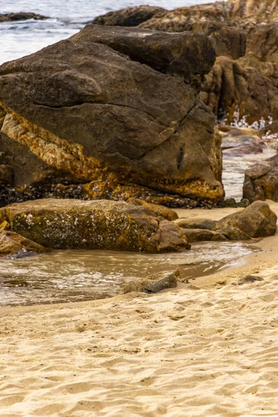Rocky Kalim Sahili tropikal sahil kıyısı turkuvaz mavisi berrak su dalgaları kum kayaları kaya ve midye kabuklu kayalar Patong Sahili Kathu Phuket Adası Güney Tayland.
