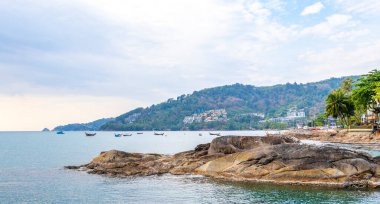 Rocky Kalim Sahili tropikal sahil kıyısı turkuvaz mavisi berrak su dalgaları kum kayaları ve kayalar Patong Sahili Kathu Bölgesi Phuket Adası Güney Tayland Bölgesi.
