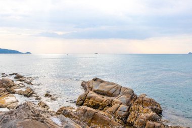 Rocky Kalim Sahili tropikal sahil kıyısı turkuvaz mavisi berrak su dalgaları kum kayaları ve kayalar Patong Sahili Kathu Bölgesi Phuket Adası Güney Tayland Bölgesi.