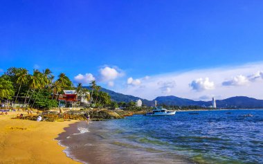 Kathu Bölgesi Phuket Adası, Tayland 06. Şubat 2026 Kalim Sahili tropikal manzara manzarası turistlerle su dalgaları palmiye ağaçları Patong Sahili Tayland 'da kayalar.