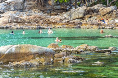 Kathu Bölgesi, Phuket Adası, Tayland 11. Şubat 2026 Kalim Sahili tropikal manzara manzarası turistlerle su dalgaları palmiye ağaçları Patong Sahili Tayland 'da kayalar.