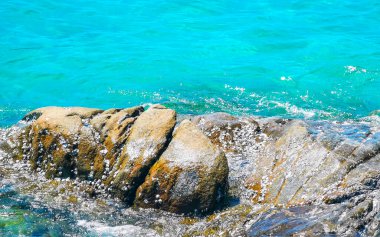Kalim Sahili kayalık tropikal sahil kıyısı turkuvaz mavisi berrak su dalgaları kum kayaları ve kayalar Patong Sahili Kathu Bölgesi Phuket Adası Güney Tayland Bölgesi.
