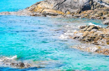 Kalim Sahili kayalık tropikal sahil kıyısı turkuvaz mavisi berrak su dalgaları kum kayaları ve kayalar Patong Sahili Kathu Bölgesi Phuket Adası Güney Tayland Bölgesi.