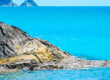Kalim Sahili kayalık tropikal sahil kıyısı turkuvaz mavisi berrak su dalgaları kum kayaları ve kayalar Patong Sahili Kathu Bölgesi Phuket Adası Güney Tayland Bölgesi.