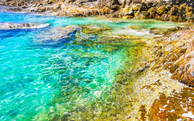 Kalim Sahili kayalık tropikal sahil kıyısı turkuvaz mavisi berrak su dalgaları kum kayaları ve kayalar Patong Sahili Kathu Bölgesi Phuket Adası Güney Tayland Bölgesi.