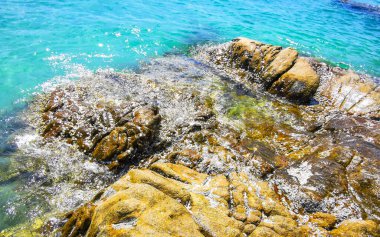 Kalim Sahili kayalık tropikal sahil kıyısı turkuvaz mavisi berrak su dalgaları kum kayaları ve kayalar Patong Sahili Kathu Bölgesi Phuket Adası Güney Tayland Bölgesi.