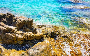 Kalim Sahili kayalık tropikal sahil kıyısı turkuvaz mavisi berrak su dalgaları kum kayaları ve kayalar Patong Sahili Kathu Bölgesi Phuket Adası Güney Tayland Bölgesi.