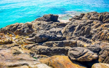 Kalim Sahili kayalık tropikal sahil kıyısı turkuvaz mavisi berrak su dalgaları kum kayaları ve kayalar Patong Sahili Kathu Bölgesi Phuket Adası Güney Tayland Bölgesi.
