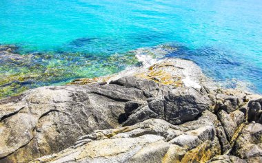 Kalim Sahili kayalık tropikal sahil kıyısı turkuvaz mavisi berrak su dalgaları kum kayaları ve kayalar Patong Sahili Kathu Bölgesi Phuket Adası Güney Tayland Bölgesi.