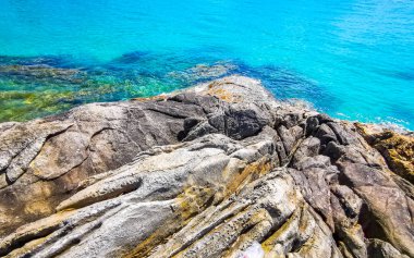 Kalim Sahili kayalık tropikal sahil kıyısı turkuvaz mavisi berrak su dalgaları kum kayaları ve kayalar Patong Sahili Kathu Bölgesi Phuket Adası Güney Tayland Bölgesi.