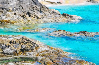 Kalim Sahili kayalık tropikal sahil kıyısı turkuvaz mavisi berrak su dalgaları kum kayaları ve kayalar Patong Sahili Kathu Bölgesi Phuket Adası Güney Tayland Bölgesi.