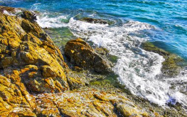 Kalim Sahili kayalık tropikal sahil kıyısı turkuvaz mavisi berrak su dalgaları kum kayaları ve kayalar Patong Sahili Kathu Bölgesi Phuket Adası Güney Tayland Bölgesi.