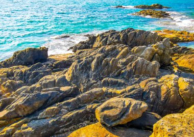 Kalim Sahili kayalık tropikal sahil kıyısı turkuvaz mavisi berrak su dalgaları kum kayaları ve kayalar Patong Sahili Kathu Bölgesi Phuket Adası Güney Tayland Bölgesi.