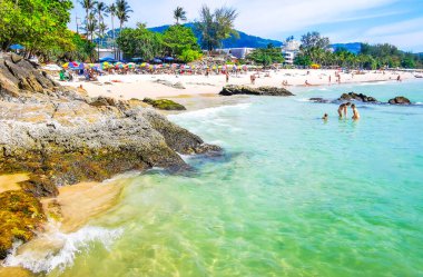 Kathu Bölgesi Phuket Adası, Tayland 14. Şubat 2026 Patong Kamala Sahili Turistlerle su dalgaları güneş şemsiyeleri tropik bitkiler ve palmiye ağaçları Phuket Tayland 'da.