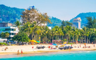 Kathu Bölgesi Phuket Adası, Tayland 25. Şubat 2026 Patong Kamala Sahili Turistlerle su dalgaları güneş şemsiyeleri tropik bitkiler ve palmiye ağaçları Phuket Tayland 'da.