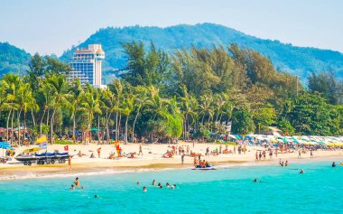 Kathu Bölgesi Phuket Adası, Tayland 25. Şubat 2026 Patong Kamala Sahili Turistlerle su dalgaları güneş şemsiyeleri tropik bitkiler ve palmiye ağaçları Phuket Tayland 'da.