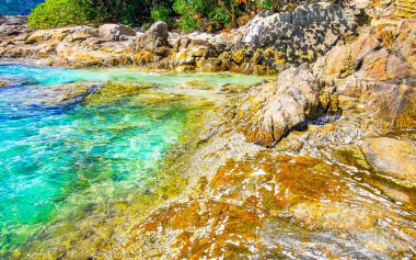 İnanılmaz kayalık Patong Kamala Sahili tropikal manzara manzarası mavi gökyüzü turkuvaz deniz suyu dalgaları palmiye ağaçları ve kayalar Patong Sahili Kathu Phuket Adası Güney Tayland.