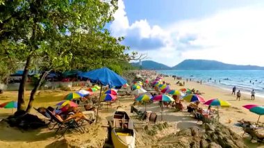 Kathu Bölgesi Phuket Adası, Tayland 06. Şubat 2026 Patong Kamala Sahili Turistlerle su dalgaları güneş şemsiyeleri tropik bitkiler ve palmiye ağaçları Phuket Tayland 'da.