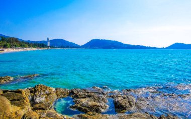 Patong Kamala Sahili tropikal manzara manzarası mavi gökyüzü turkuvaz deniz suyu dalgaları palmiye ağaçları ve bulutlar Patong Sahili 'nde Kathu Phuket Adası Güney Tayland.