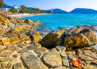 Patong Kamala Sahili tropikal manzara manzarası mavi gökyüzü turkuvaz deniz suyu dalgaları palmiye ağaçları ve kayalar Patong Sahili 'nde Kathu Phuket Adası Güney Tayland.