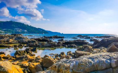 Tropikal Kalim Sahili kayalık sahil kıyısı turkuvaz mavisi açık deniz dalgaları kum kayaları ve kayalar Patong Sahili Kathu Bölgesi Phuket Adası Güney Tayland Bölgesi.