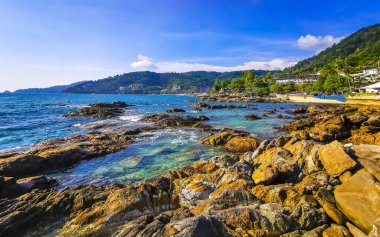 Tropikal Kalim Sahili kayalık sahil kıyısı turkuvaz mavisi açık deniz dalgaları kum kayaları ve kayalar Patong Sahili Kathu Bölgesi Phuket Adası Güney Tayland Bölgesi.