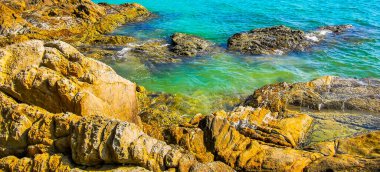 Kalim Sahili kayalık tropikal sahil kıyısı turkuvaz mavisi berrak su dalgaları kum kayaları ve kayalar Patong Sahili Kathu Bölgesi Phuket Adası Güney Tayland Bölgesi.