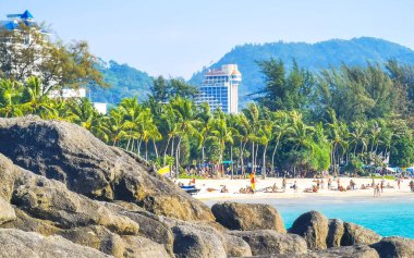 Kathu Bölgesi Phuket Adası, Tayland 25. Şubat 2026 Patong Kamala Sahili Turistlerle su dalgaları güneş şemsiyeleri tropik bitkiler ve palmiye ağaçları Phuket Tayland 'da.