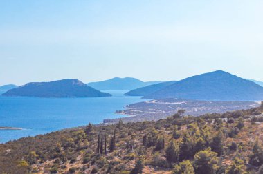 Sahil kıyısı turkuvaz mavi su dalgaları ada adaları dağ tepeleri kayalık tepeler uçurumlar ve Dubrovnik Neretva İlçesi Dalmaçya Bölgesi 'ndeki mavi gökyüzü manzarası Hırvatistan.