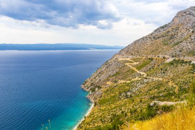Sahil kıyısı turkuvaz mavi su dalgaları ada adaları dağ tepeleri kayalık tepeler kayalıklar ve Dubrovnik Neretva İlçesi Dalmaçya Bölgesi 'nde yol manzarası.